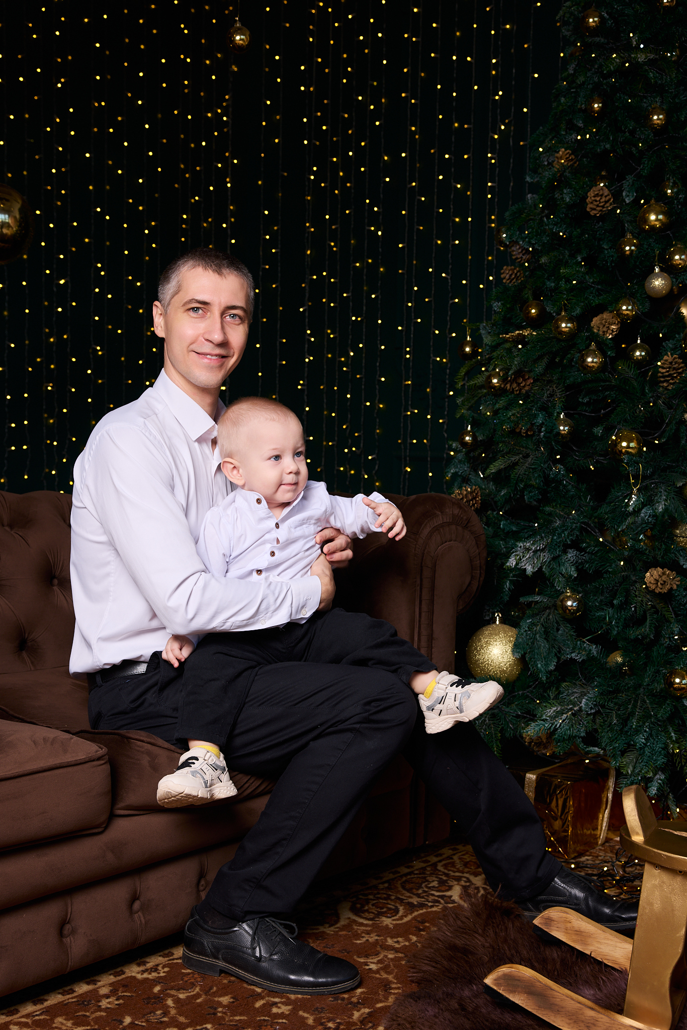 Семейная новогодняя фотосессия в Ростове-на-Дону — папа с сыном на диване у ёлки