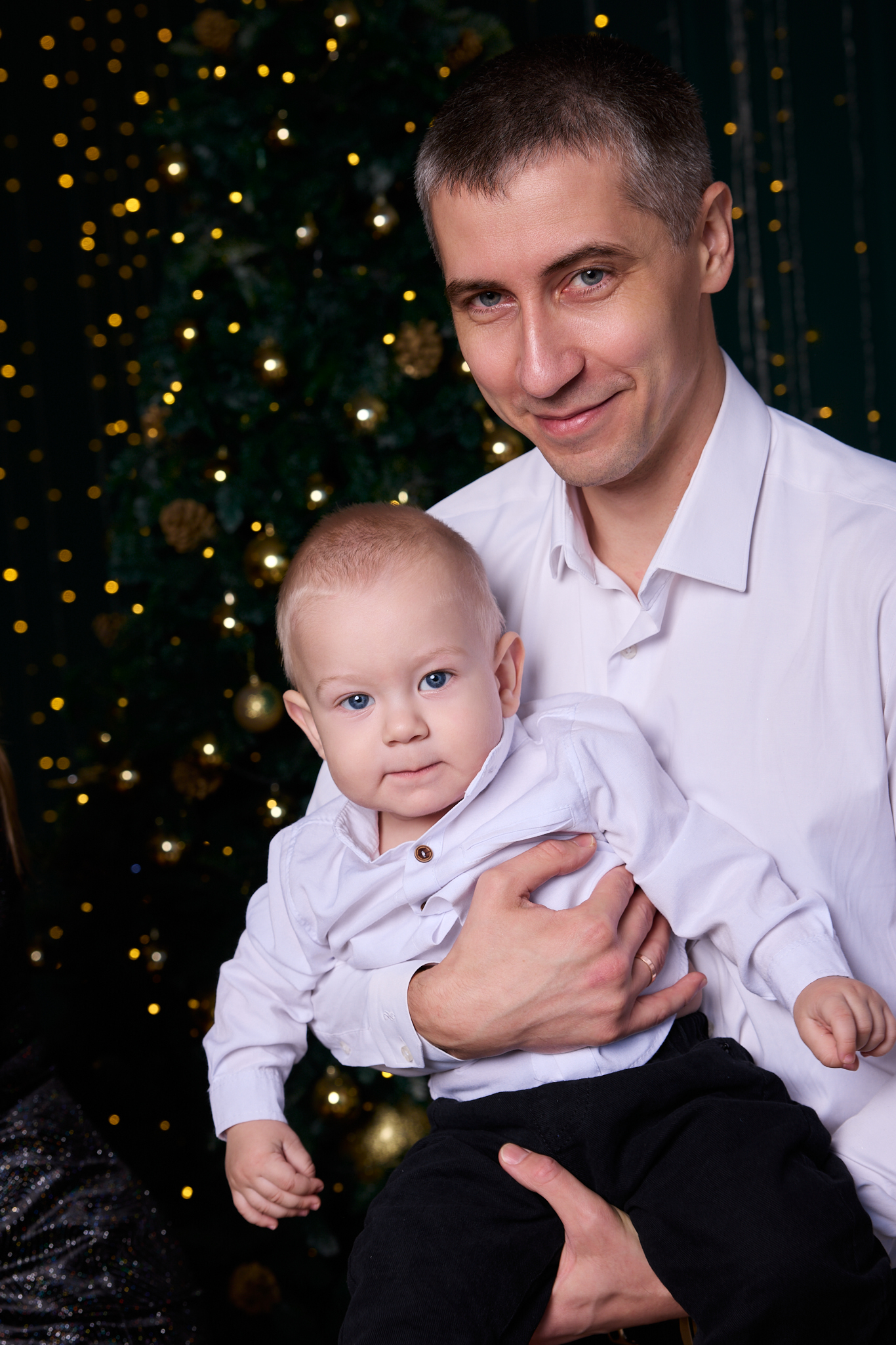 Семейная новогодняя фотосессия в Ростове-на-Дону — папа с сыном на руках у ёлки